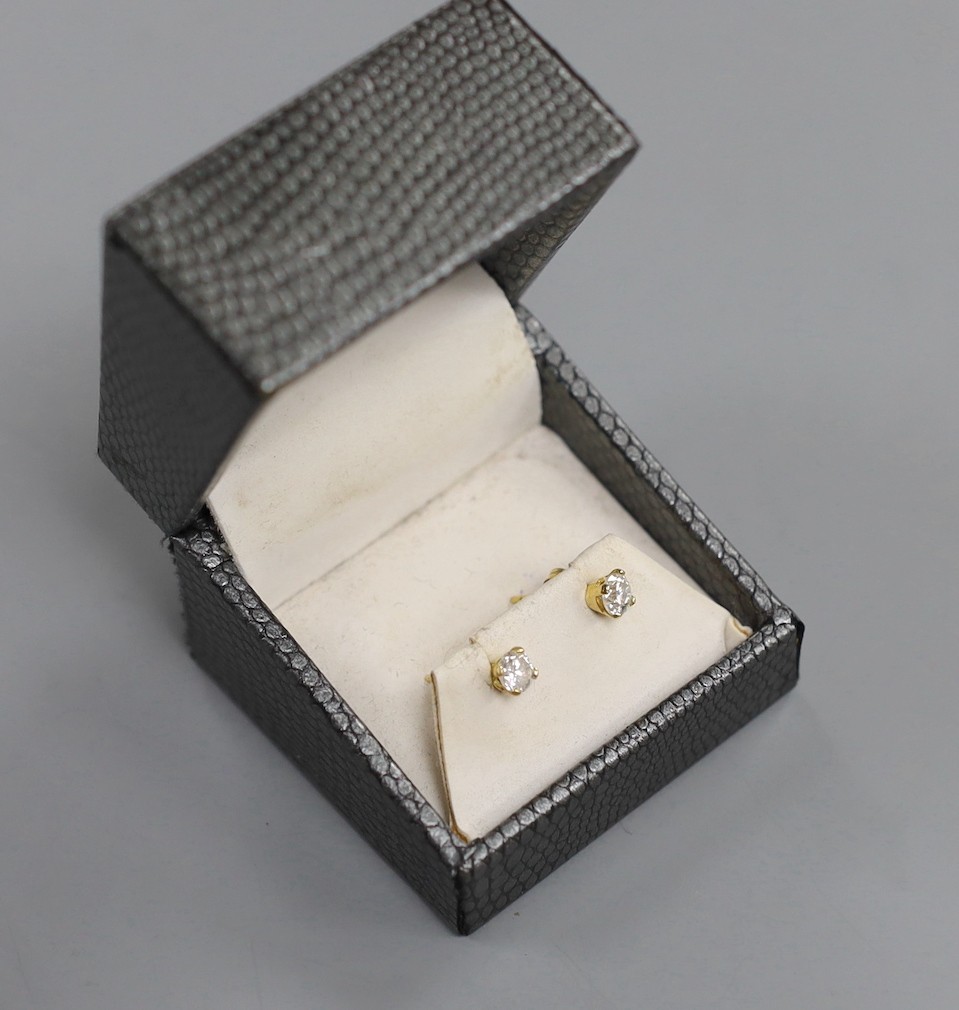 A pair of 18kt and solitaire diamond set ear studs, gross weight 1.2 grams.